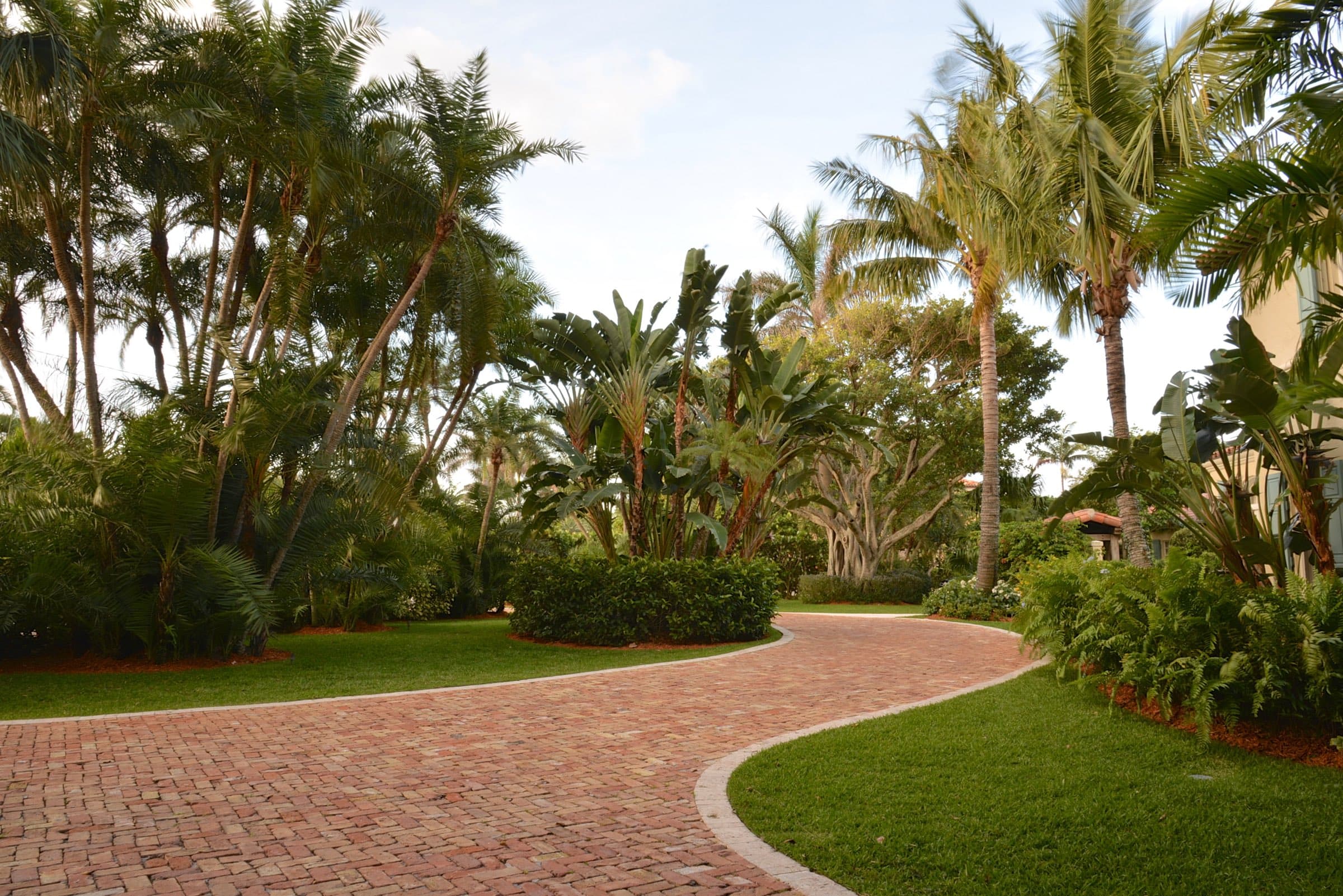 Lush private garden with layered tropical plantings and a shaded path in Delray Beach