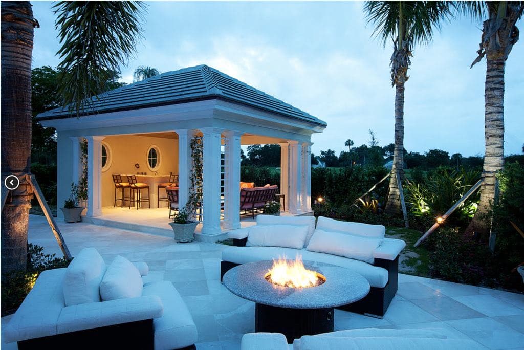 Outdoor firepit lounge set within a planted garden at a Village of Golf estate